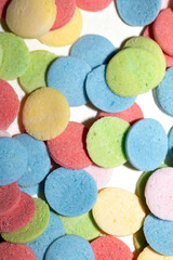 Close up of sugar paper confetti circle spots and colour dots on white background