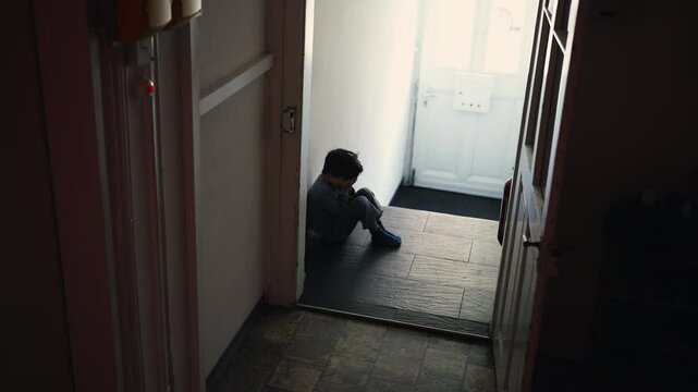 Little Boy in Crisis, Seated Alone in Shadowy Home Hallway, Hiding Face in Hands, Experiencing Deep Despair and Isolation, child struggling with shame alone, childhood depression concept