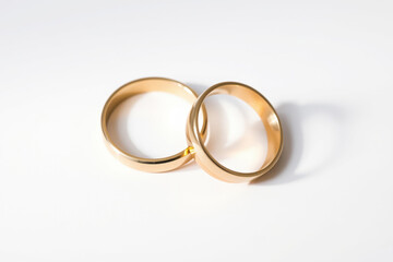 symbolic unity: two gold wedding rings touching on white background concept of love, marriage, commitment