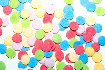 Close up of sugar paper confetti circle spots and colour dots on white background