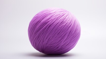 Colorful purple yarn ball resting on a plain surface showcasing its smooth texture and vibrant hue for crafting projects