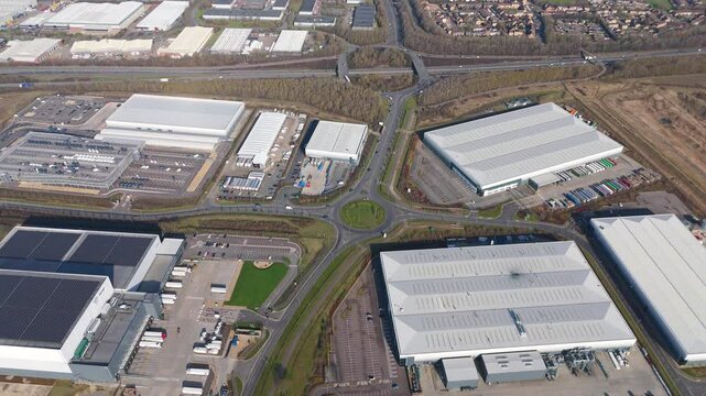 Aerial view drone flight above business park warehouse district factory units data centre quantum computing on a sunny day in the UK logistics and transport of goods economics 