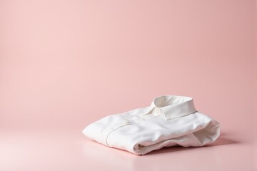 Obraz premium Minimalist dress shirt neatly folded on a pastel dusty pink canvas