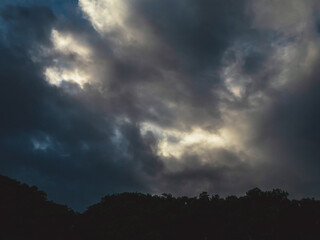 Dark rain cloud dramatic sky summer tropical thunder storm sky and fluffy black darkness cloud nearly raining cloudscape. Nimbus raincloud skyline climate background. Dark gray sky cloudy environment