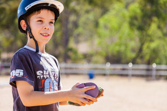 Smiling child cleaning horse brushes - currycomb