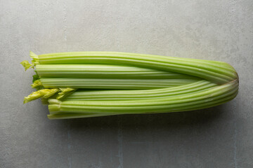 green celery on a gray concrete background, close-up