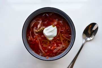 Ukrainian borscht in a bowl on a light background, home cooking