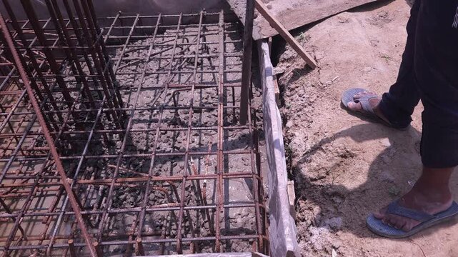 Construction workers using reinforced tmt steel bar with ease at the construction site, Reinforced bar (rebar). TMT steel rods tied together forming the core of concrete