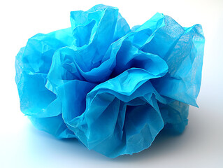 Vibrant blue tissue paper artfully crumpled into a flowerlike form.  A striking abstract image conveying concepts of fragility, growth, and potential.
