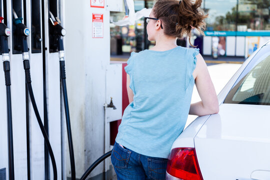 Young woman filling up her car with petrol at the servo