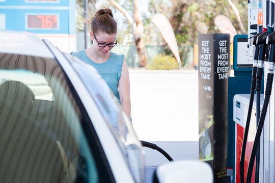 Young woman filling up car at petrol pump