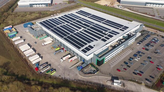 Aerial view drone flight above business park warehouse district factory units data centre quantum computing on a sunny day in the UK logistics and transport of goods economics 