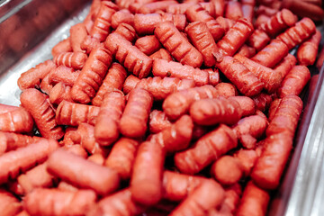 Fried small sausages. Cooking dinner. Harmful and high-calorie food.