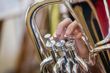 Close-up of a musician's hand playing the tuba