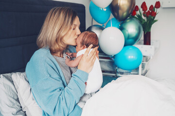After baby delivery mother and baby at home. Mother holds her newborn in hands. Mom and baby...