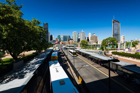 Overhead view of buses at bus station leading to bridge and city skyline
