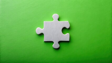 Obraz premium Single White Jigsaw Puzzle Piece on Green Background, Representing Solution, Completion, or a Missing Part of a Larger Project