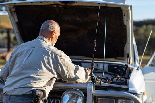 person looking under bonnet of four-wheel-drive vehicle