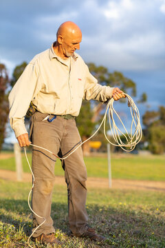 man holding electrical extension cord like a lasso