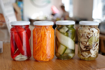 Variety of pickle jars lined up on counter in cafe