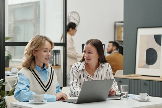 Portrait of two smiling young girls enjoying work together in modern office gen z entrepreneurs