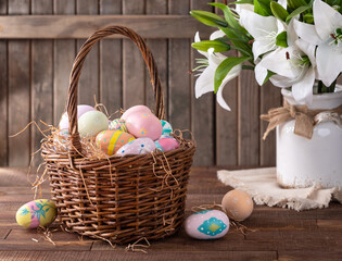 Decorated Easter eggs in a basket with white lilies