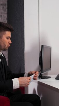 Business people sign contract in office. Young attractive handsome client give envelope with dollars to manager businesswoman. She count summ and approve deal. Vertical Shot.