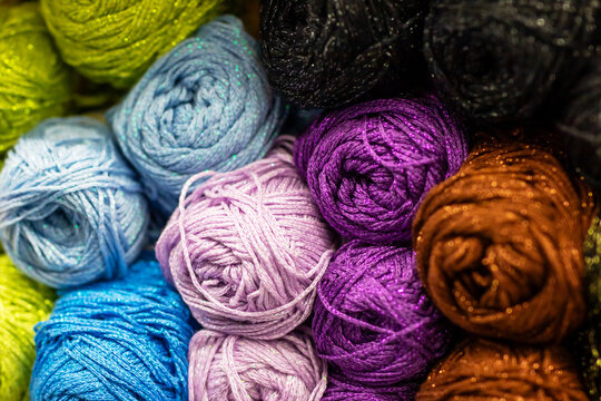A collection of colored yarn balls stacked neatly together in a bunch