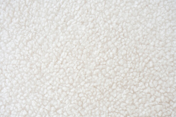 A highly detailed close-up of fluffy white sherpa fleece with a textured surface. This fabric, crafted from recycled polyester, offers warmth and comfort for sustainable fashion, outerwear, textiles.