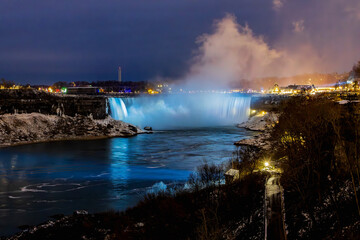 Niagara Falls by night with projected beautiful colours illuminating  the waterfall, Ontario, Canada.