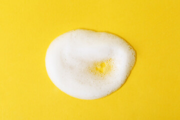 Sample of fluffy foam on orange background, top view
