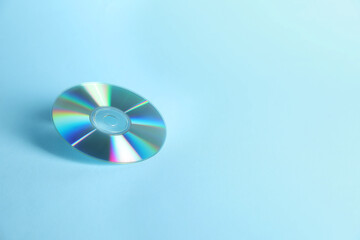 One shiny compact disc on light blue background. Space for text