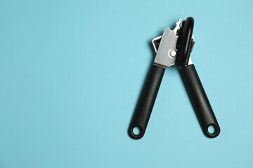 One can opener on light blue background, top view. Space for text