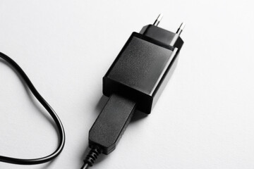 USB power adapter with charge cable on white background, closeup
