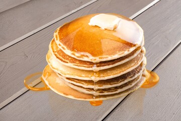 Fluffy sweet pancakes stacked with syrup