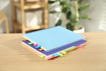 Notebooks with colorful tabs on wooden table indoors