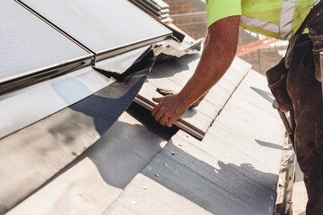 Skilled worker installing solar panels on a residential roof