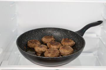 Frying pan with meat in fridge