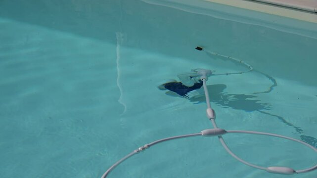 Automatic pool cleaner cleaning on the bottom of a swimming pool