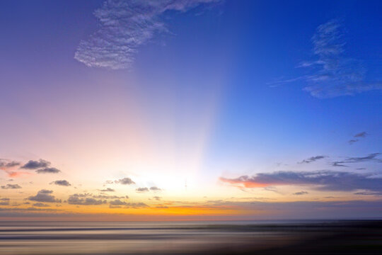 Sunrise over the sea. Light of the beautiful sunset over horizon in the beach with colorful sky. Sunset sunrise sky background. Sky clouds backgrounds. Romantic sunset. Morning light of the sunrise.