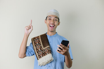 Asian Muslim man holding smartphone with facial expression
