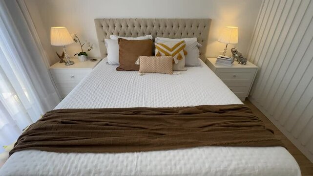 cama arrumada com cabeceira de luxo capitone e tons decora&ccedil;&atilde;o amarela e tons marrons 