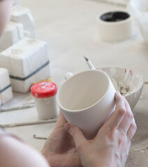 A young woman makes ceramics in her own workshop