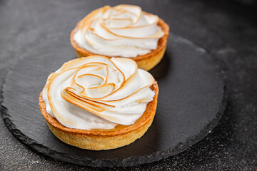 Lemon tart sweet dessert meringue, lemon curd, shortcrust pastry tasty fresh delicious gourmet food background table rustic food top view copy space