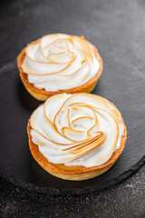 Lemon tart sweet dessert meringue, lemon curd, shortcrust pastry tasty fresh delicious gourmet food background table rustic food top view copy space