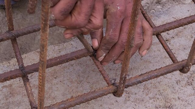 Construction workers using reinforced tmt steel bar with ease at the construction site, Reinforced bar (rebar). TMT steel rods tied together forming the core of concrete