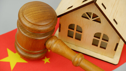 Law and real estate business in China. Gavel with wooden house on Chinese flag.