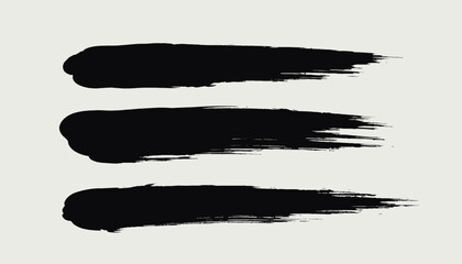 Fototapeta premium Three black textured paint brush strokes on white