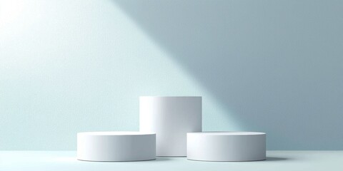 Minimalist White Cylindrical Display Platforms Against a Light Blue Textured Wall