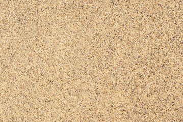 Smooth golden sand texture spread across a beach area inviting relaxation and leisure activities
